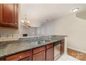 A kitchen with granite counters and stainless dishwasher opens up into a living space at 321 Rose Garden Ct, Rock Hill, SC 29732