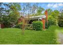 Charming red brick home featuring a well-manicured lawn and mature landscaping at 3221 Cosby Pl, Charlotte, NC 28205