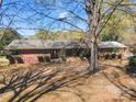 Attractive single-story brick home featuring lush greenery and mature trees at 3609 Southwood Dr, Gastonia, NC 28056
