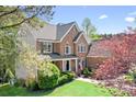An exterior view showcasing the roofline of the beautiful brick home with mature trees at 3934 Blue Dory Ln, Denver, NC 28037