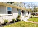 Brick home showcasing manicured landscaping and a light blue front door and white window frames at 4343 Dowling Dr, Charlotte, NC 28205