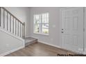 Bright entryway featuring hardwood floors, staircase and a white front door at 5152 Tommy Ln # 1303, Stanley, NC 28164