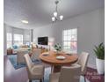 Open-concept dining and living area with hardwood floors and neutral decor at 5670 Hammermill Dr, Harrisburg, NC 28075