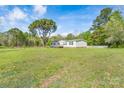 Expansive green backyard of a single-story home beneath a bright blue sky and scattered clouds at 574 Pamela Rd, York, SC 29745