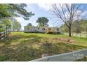 Backyard with white fence, mature trees, and wooden deck, offering privacy and charm at 574 Pamela Rd, York, SC 29745