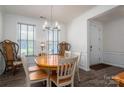 Bright dining room with a chandelier, wood flooring, and natural light streaming through large windows at 7924 Creek Park Dr, Denver, NC 28037