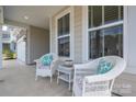 Inviting front porch featuring comfortable wicker chairs, perfect for relaxing and enjoying the outdoors at 7924 Creek Park Dr, Denver, NC 28037