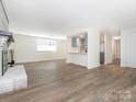 An open floor plan with hardwood floors connecting the living room, dining area, and kitchen at 8432 Strider Dr, Charlotte, NC 28212