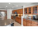 Well-lit kitchen with wood cabinets, stainless steel appliances, and tile backsplash and flooring at 103 Karlyn Ct, Mooresville, NC 28115