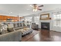 Bright living room with fireplace, ceiling fan, hardwood floors, and open concept leading to kitchen at 103 Karlyn Ct, Mooresville, NC 28115