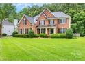 Beautiful brick home featuring manicured lawns, dark shutters and a welcoming covered entryway at 1102 High Brook Dr, Waxhaw, NC 28173