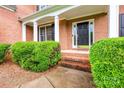 Close-up of brick steps leading to a black front door with sidelights and decorative trim at 1102 High Brook Dr, Waxhaw, NC 28173