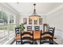 Elegant dining room with wood table, seating for six, and a stylish chandelier for warm ambient light at 11615 Hidden Grove Trl, Charlotte, NC 28215