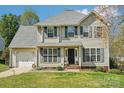 Charming two-story home featuring a well-manicured lawn and attached garage at 11615 Hidden Grove Trl, Charlotte, NC 28215