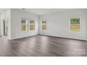 Spacious living room with wood-look floors, three bright windows, and neutral paint at 1234 Morehead Dr, Salisbury, NC 28144
