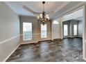 Elegant dining room features laminate floors, a tray ceiling, and a chandelier at 1240 Periwinkle Dr, Waxhaw, NC 28173
