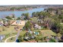 Aerial view of estate at 127 Castle Dr featuring lake, pool, and large manicured lawn at 127 Castle Dr, Mooresville, NC 28117