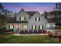 Charming two-story home with a well-manicured lawn at dusk at 127 Castle Dr, Mooresville, NC 28117