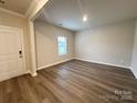 Well-lit living room with hardwood floors, neutral walls, and an open doorway, providing a welcoming atmosphere at 1986 Paddlewheel Dr, Stanley, NC 28164