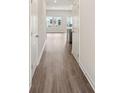Hallway leading to an open space with hardwood floors and neutral paint throughout at 2020 Old Rivers Rd, Concord, NC 28027