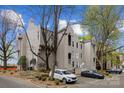 Multi-story building with gray siding, manicured landscaping, and multiple parked vehicles at 306 S Cedar St # 10, Charlotte, NC 28202