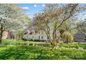 Beautiful home with manicured lawn, mature trees, and blooming flowers in a well-maintained landscape at 3717 Bodenham Ct, Charlotte, NC 28215
