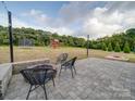 Spacious backyard featuring a stone patio, fire pit, and playground at 3810 New Salem Rd, Monroe, NC 28110