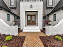 Elegant entryway showcasing a brick walkway that leads to the custom double doors and white brick entry at 406 Sugar Maple Ln, Weddington, NC 28104