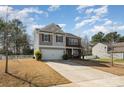 Well-manicured two-story home with a two-car garage and a neatly landscaped front yard under a bright sky at 428 Wheat Field Dr, Mount Holly, NC 28120