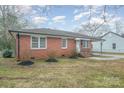 Charming brick home featuring a covered parking area and landscaped front yard on a partly cloudy day at 108 White Oak St, Chester, SC 29706
