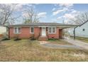 Charming brick home featuring a covered parking area, landscaped front yard, and inviting front porch on a partly cloudy day at 108 White Oak St, Chester, SC 29706