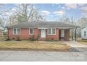 Charming brick home featuring a covered parking area and landscaped front yard on a foggy day at 108 White Oak St, Chester, SC 29706