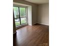 Bedroom with wood-look floors and a large window overlooking the front yard at 11022 Harrowfield Rd, Charlotte, NC 28226
