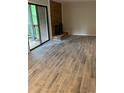 Open living area featuring wood-look tile flooring and brick fireplace with sliding glass doors to the deck at 11022 Harrowfield Rd, Charlotte, NC 28226