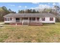 The exterior of this charming single-story home shows a wide porch, red shutters, and a well-maintained green lawn at 130 Golfers Dr # 1, Salisbury, NC 28146