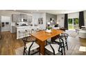 Open concept space with a dining table, counter seating, and views into the living room at 146 Falling Up Ln, Salisbury, NC 28147