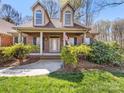 Inviting front porch with brick columns, decorative bushes, and a clear view of the front door at 153 Stafford Estates Dr, Salisbury, NC 28146