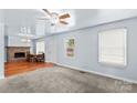 Bright living room featuring neutral carpet, ceiling fan, and a fireplace that adds a cozy focal point at 1725 Bristol Rd, Statesville, NC 28677