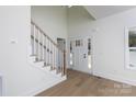 Bright foyer boasts high ceilings, a staircase with wooden handrail, and a view of the front door at 202 Westerwood Dr, Rock Hill, SC 29732