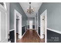Inviting hallway with hardwood floors, wainscoting, and chandelier, creating a warm and elegant entry at 203 Jackson St, Fort Mill, SC 29715