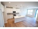 Open-concept kitchen boasts an island with quartz countertops and stainless steel appliances at 219 Halemarg Dr, Belmont, NC 28012