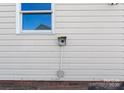 Close-up of home exterior, highlighting the siding and brick foundation, with visible utility connections at 238 Lippard Springs Cir, Statesville, NC 28677