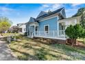 Side view of the charming blue home with a quaint covered porch and landscaped yard at 311 W Center Ave, Mooresville, NC 28115