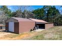 Exterior view of a spacious barn with a large roll-up door and open bay for equipment or vehicle storage at 4875 Sulpher Springs Ne Rd, Hickory, NC 28601