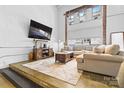 Bright living room with neutral tones, plush sofa, industrial windows, and modern decor at 925 Westmere Ave, Charlotte, NC 28208