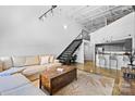 Open living space with exposed beams, metal staircase, and a modern kitchen backdrop at 925 Westmere Ave, Charlotte, NC 28208