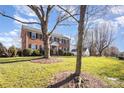 Brick two-story home with black shutters, set on a large, grassy lot with mature trees at 9255 Deer Spring Ln, Charlotte, NC 28210