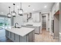 New kitchen features light gray cabinets, stainless appliances, a pantry and an island with sink and pendant lighting at 9934 Cask Way, Huntersville, NC 28078
