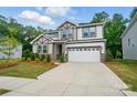 Two-story home featuring a 2-car garage, stone accents, craftsman style architecture, and landscaped yard at 9957 Cask Way, Huntersville, NC 28078