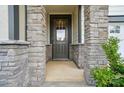 Inviting front entrance with stone pillars and gray front door with glass pane at 9957 Cask Way, Huntersville, NC 28078